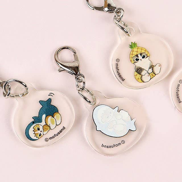The Mofusand Mini Keychain Charm 2 Piece Set by Mofusand features cute cartoon animal designs with metal clasps, displayed as adorable accessories on a light pink background.