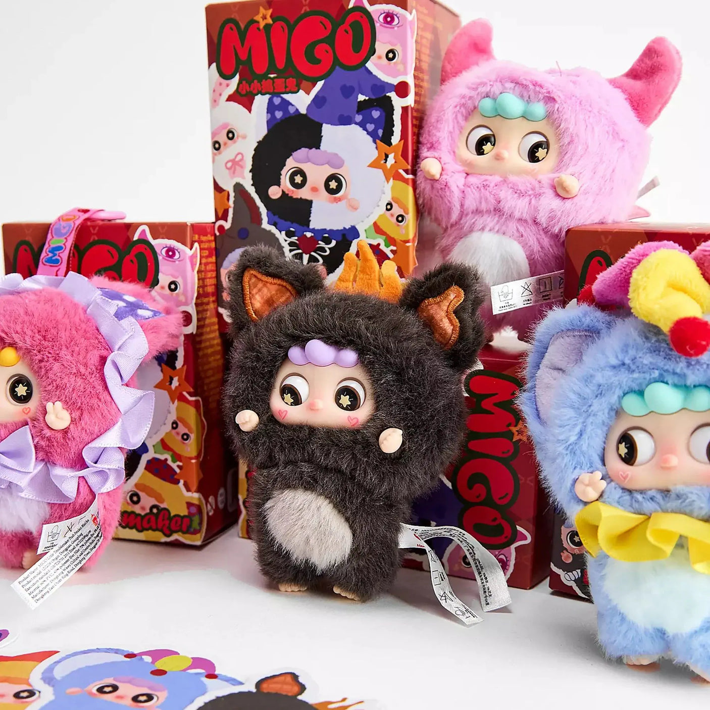 Furry plush character pendants with bows in pink, black, and blue