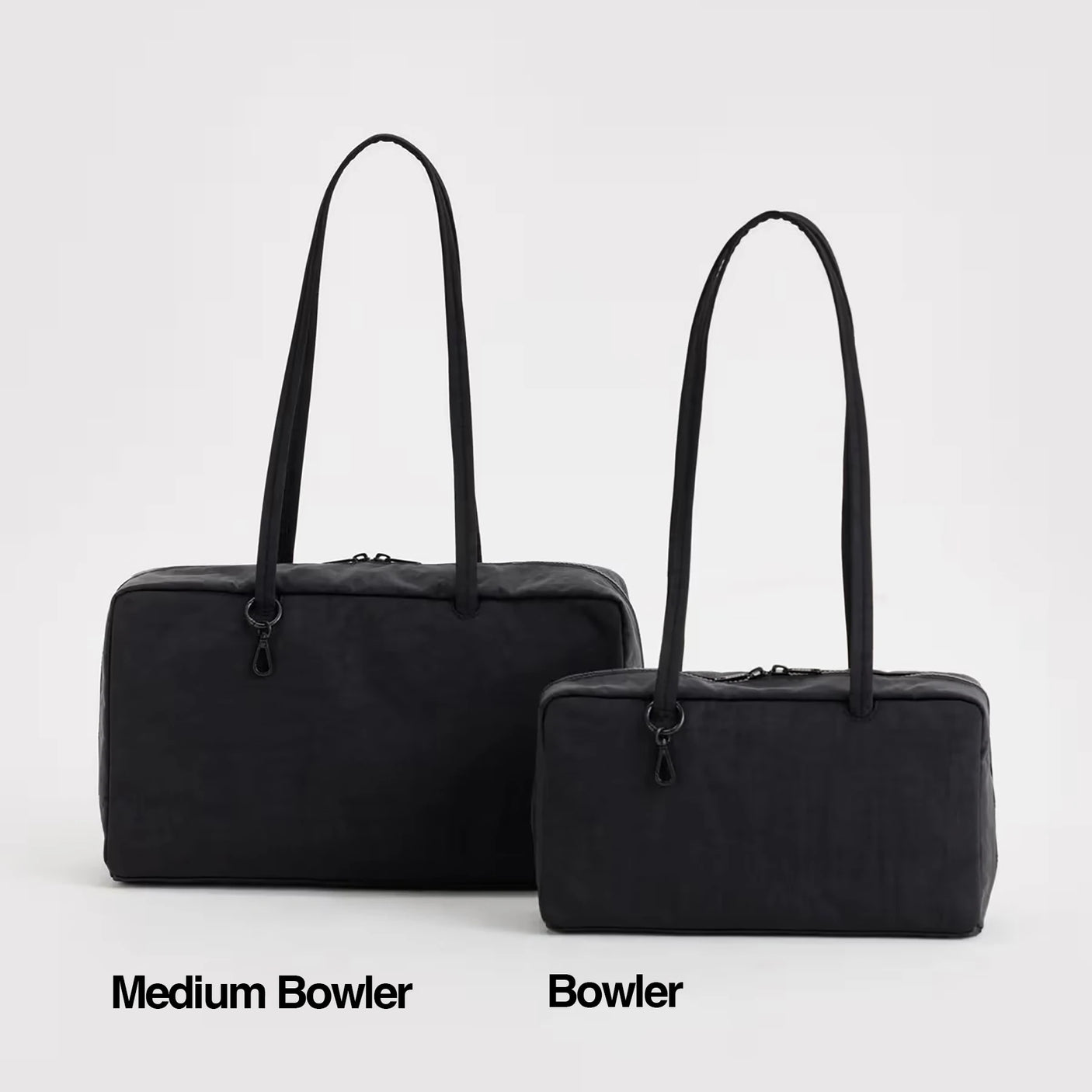Two black bowler bags with long straps sit side by side on a white background. The left is the Baggu Medium Nylon Bowler Bag - Black by Baggu; the right is labeled "Bowler.