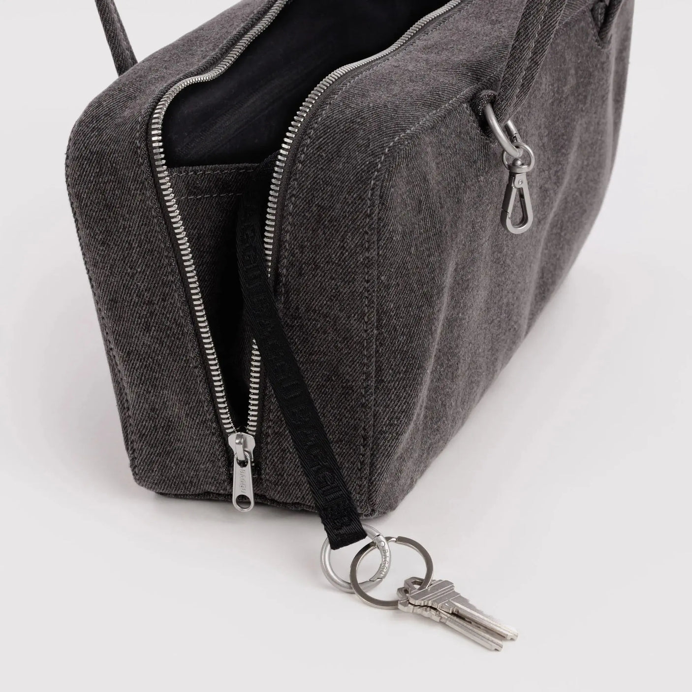 Washed black denim bowler bag open, showing zippers and keyring with keys.