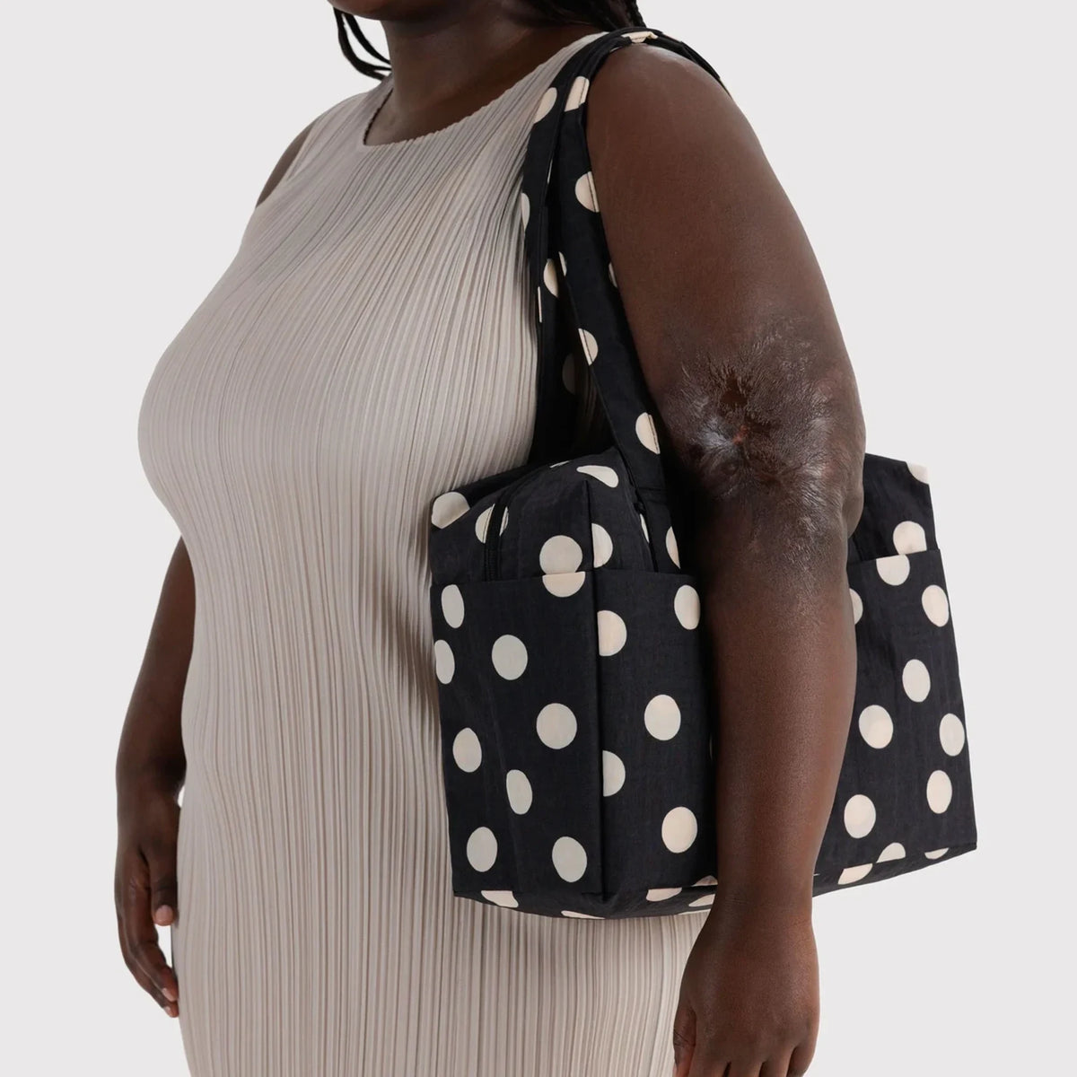 Black polka-dot tote bag with cream dots, short handles