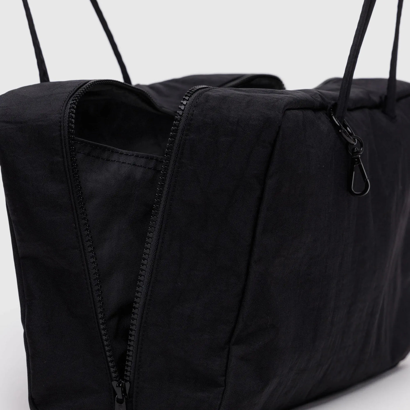 Black medium nylon bowler bag close-up with zippered side panel and zipper pull