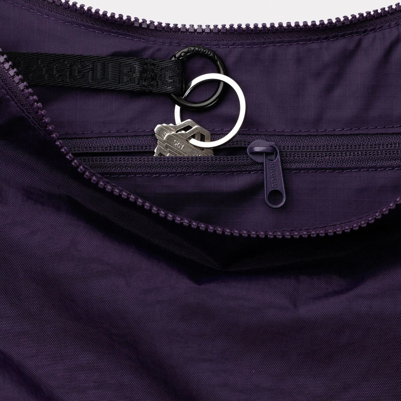 Medium crescent nylon bag in dark purple with zip closure and metal key ring