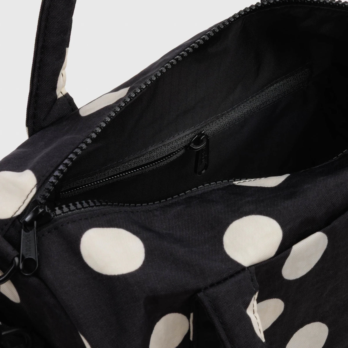 Polka-dot nylon duffle bag with zipper opening and black interior lining