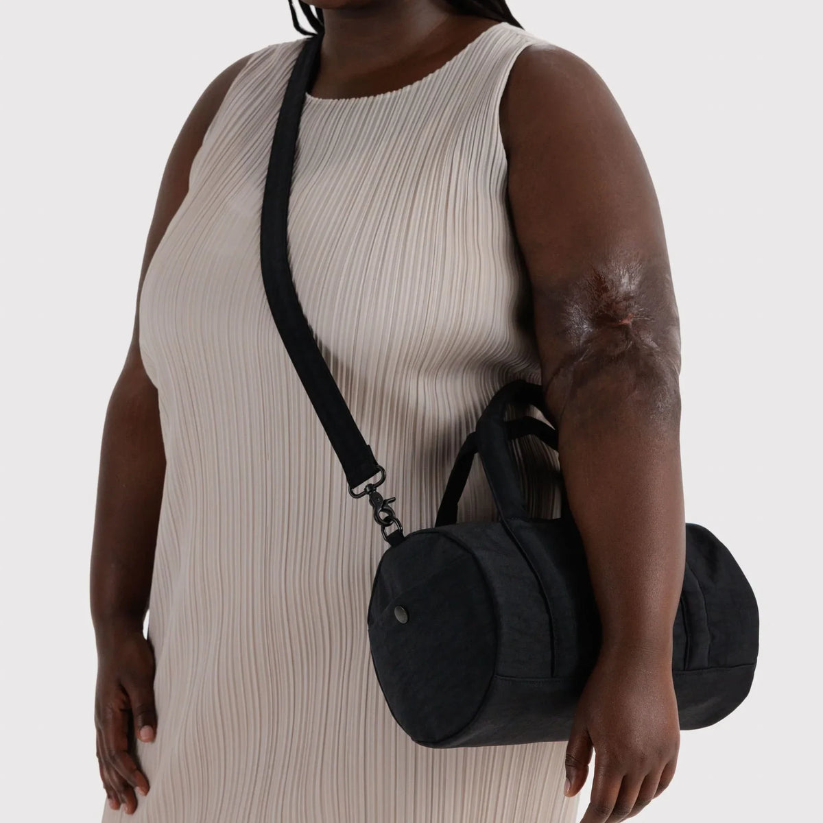 Black nylon duffle bag with adjustable shoulder strap, carried crossbody