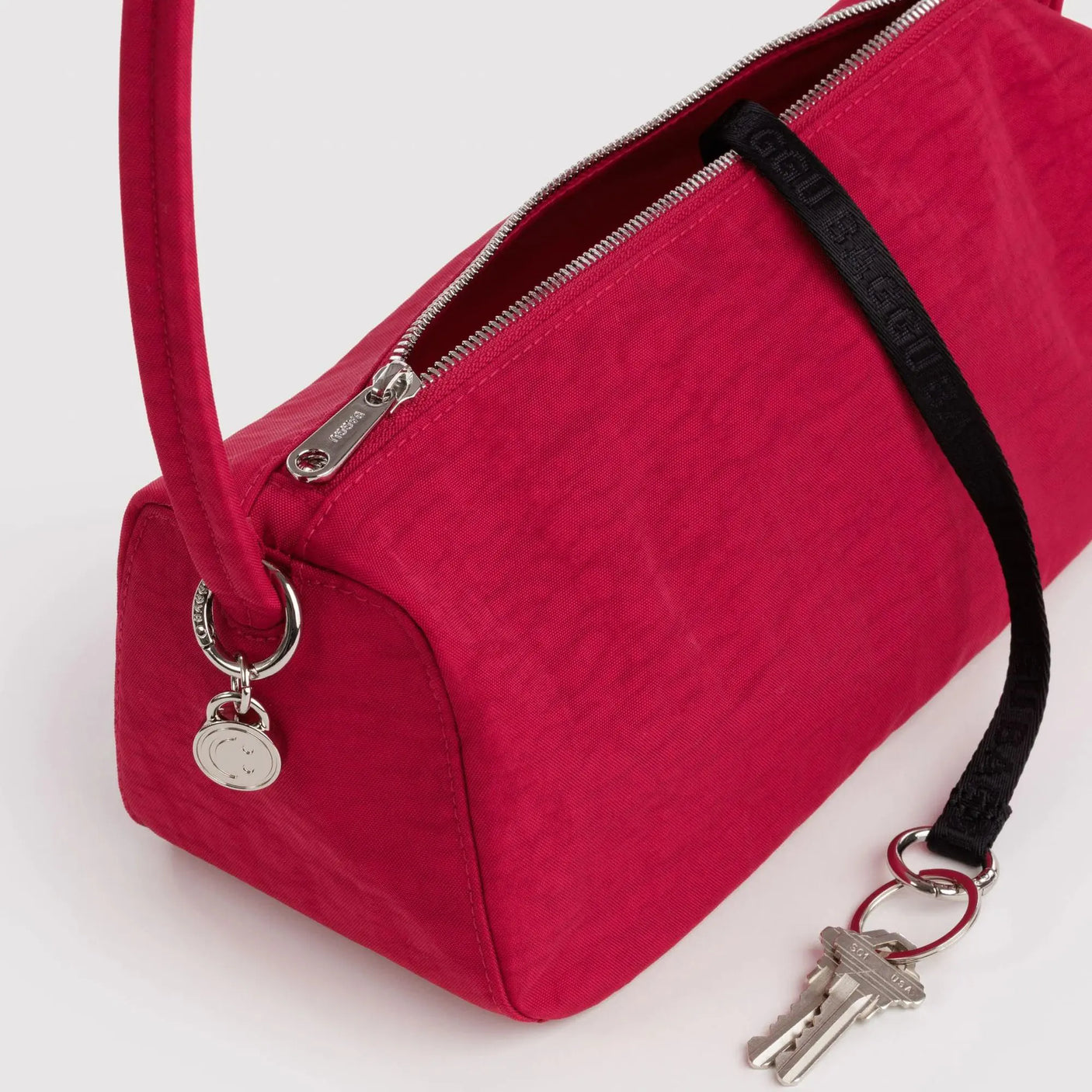 Cherry red nylon zip-top loaf bag detail with metal keyring and zipper pull