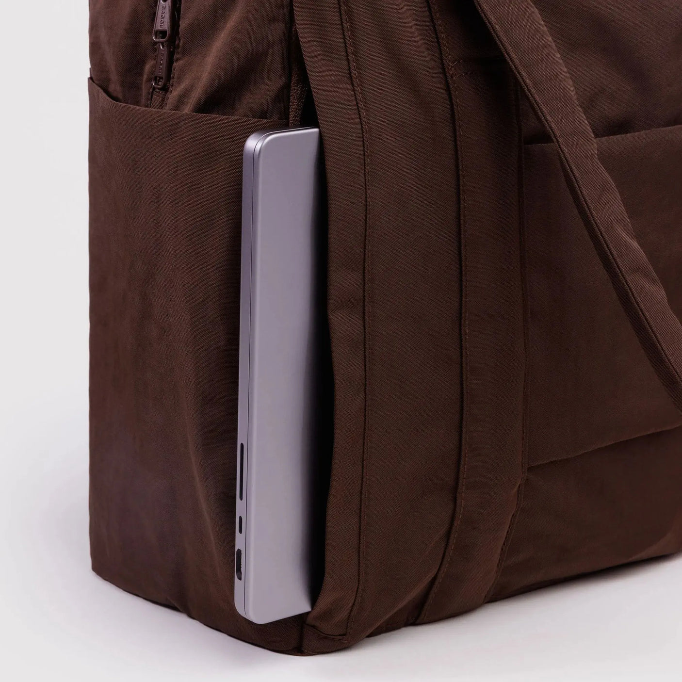 Coffee-brown carry-on bag with side zip pocket and tablet-sized device inside