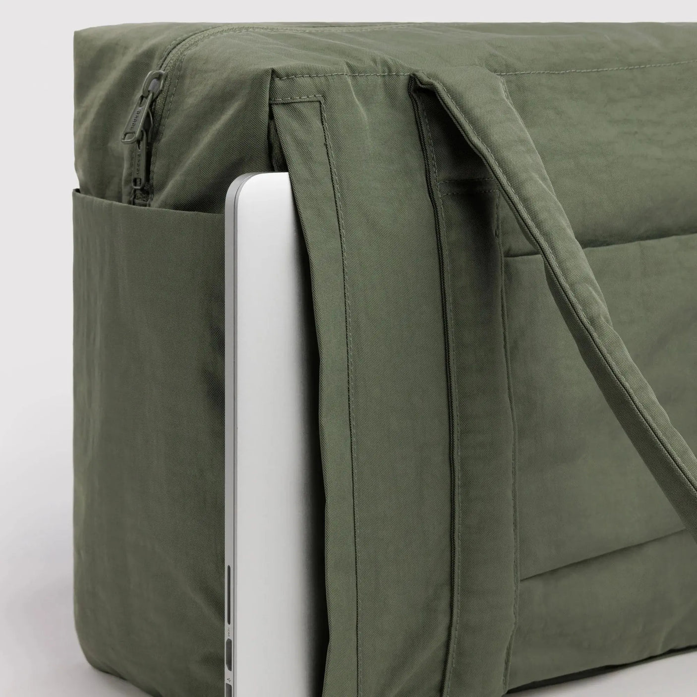 Olive green cloud carry-on tote bag with suitcase sleeve and front zip pocket, close-up