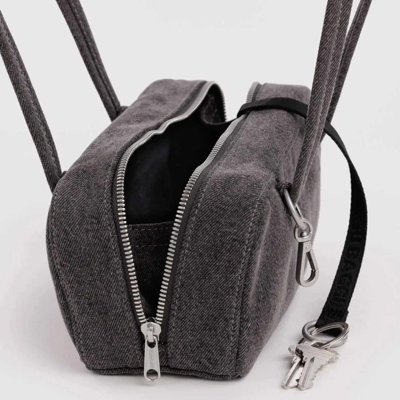 Washed black denim bowler bag with open top, black lining, dual zippers and key clip