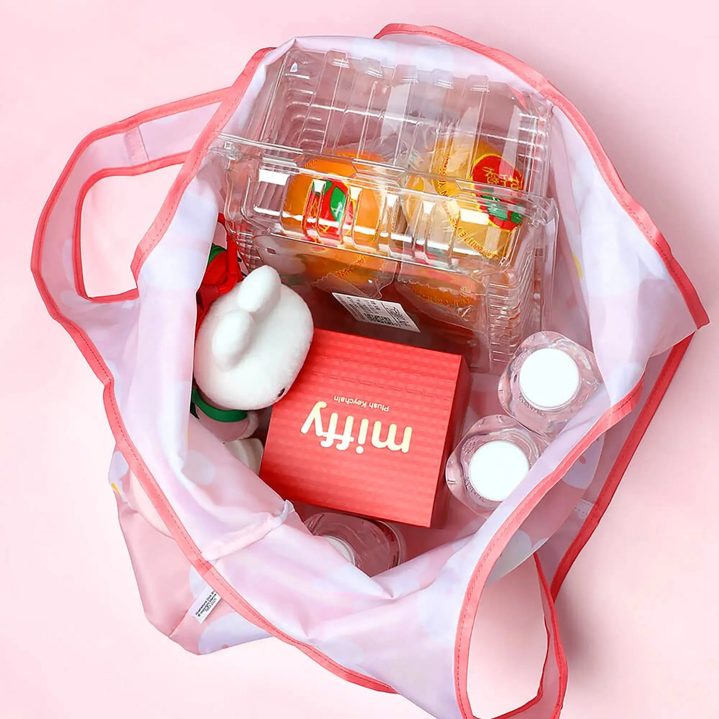 White plush rabbit keychain with red box inside clear vinyl tote bag with pink handles