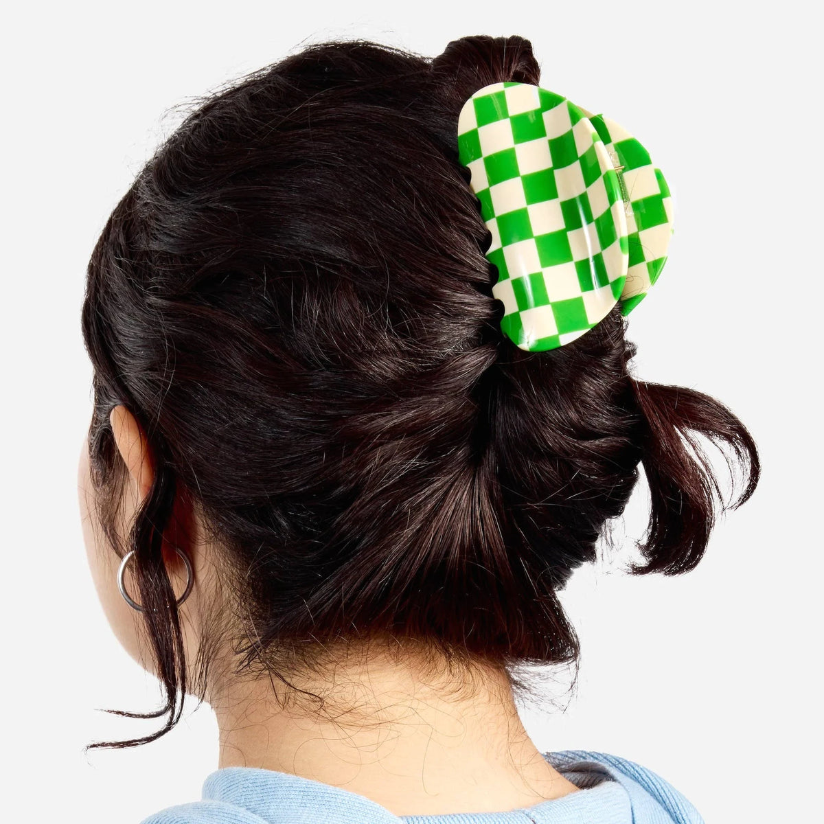 Green and white checkered claw clip worn in hair, side view