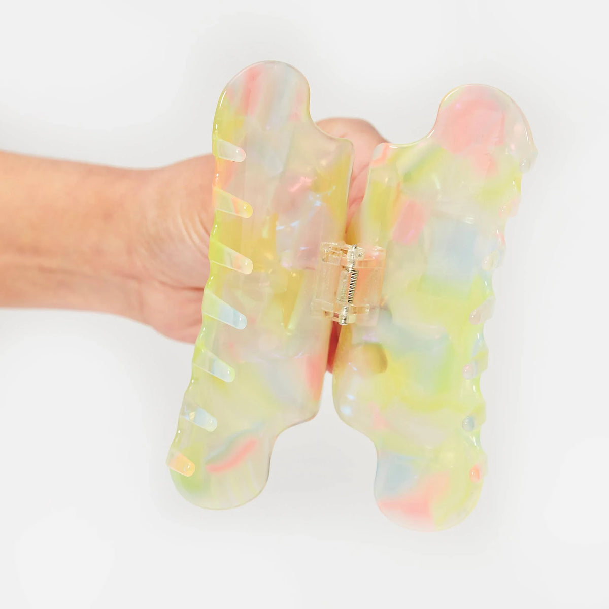 Pastel sherbet translucent claw clip, side view, open hinge and teeth visible