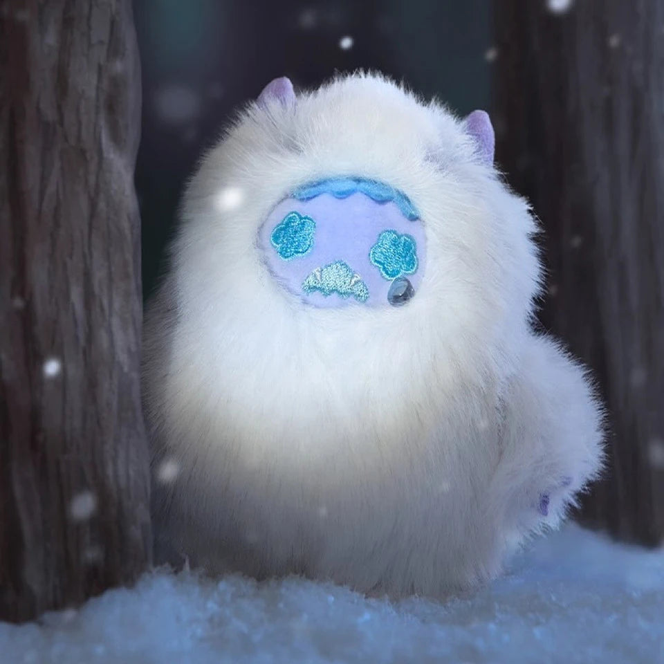 Fluffy white plush from Finding Unicorn Shinwoo Cold Hugs Blind Box with blue stitched face and small purple horns in snowy forest
