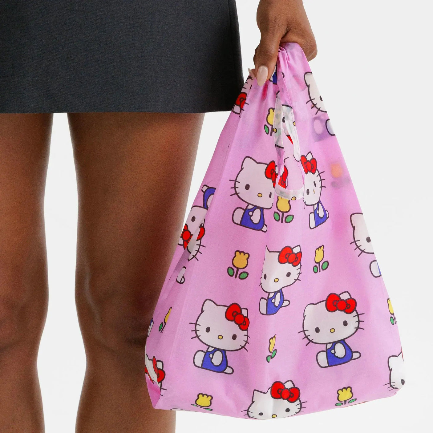 Pink Hello Kitty baby tote bag held by person, character icons allover