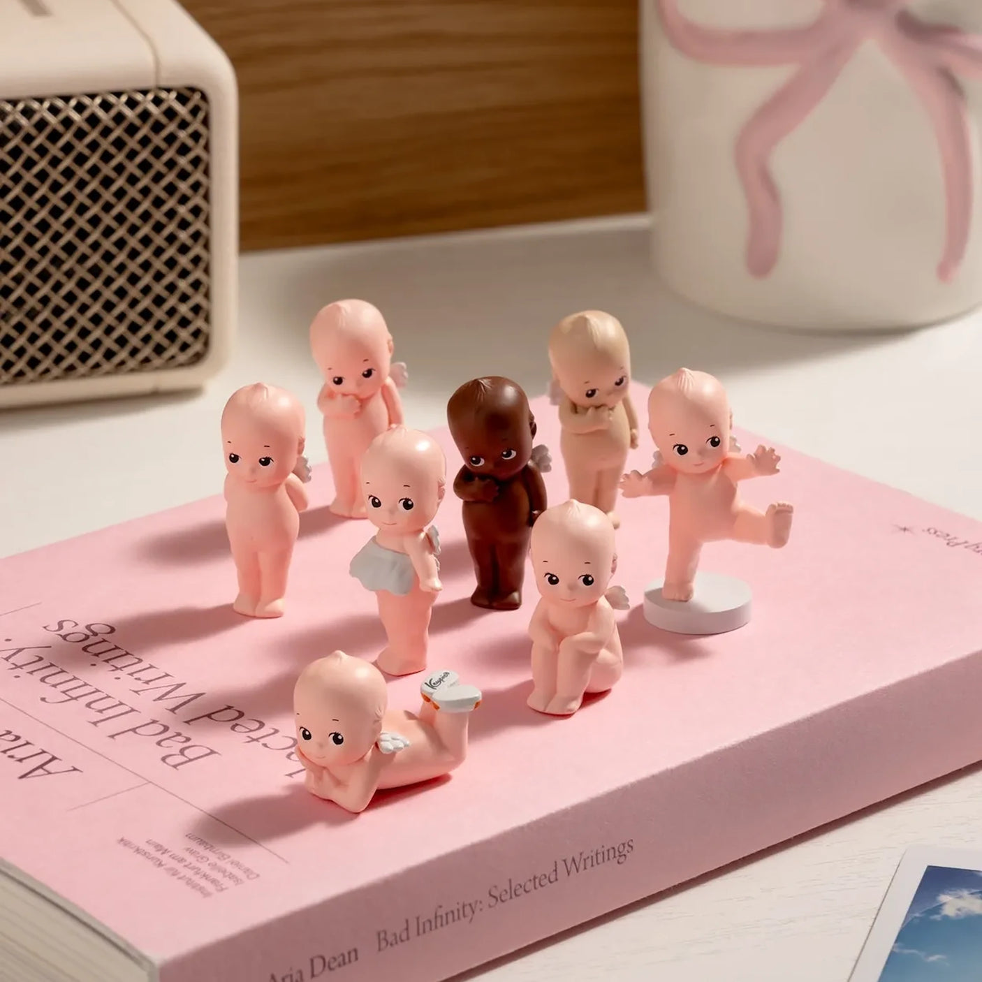 Mini blind box baby figure collection standing on small round bases, assorted tones