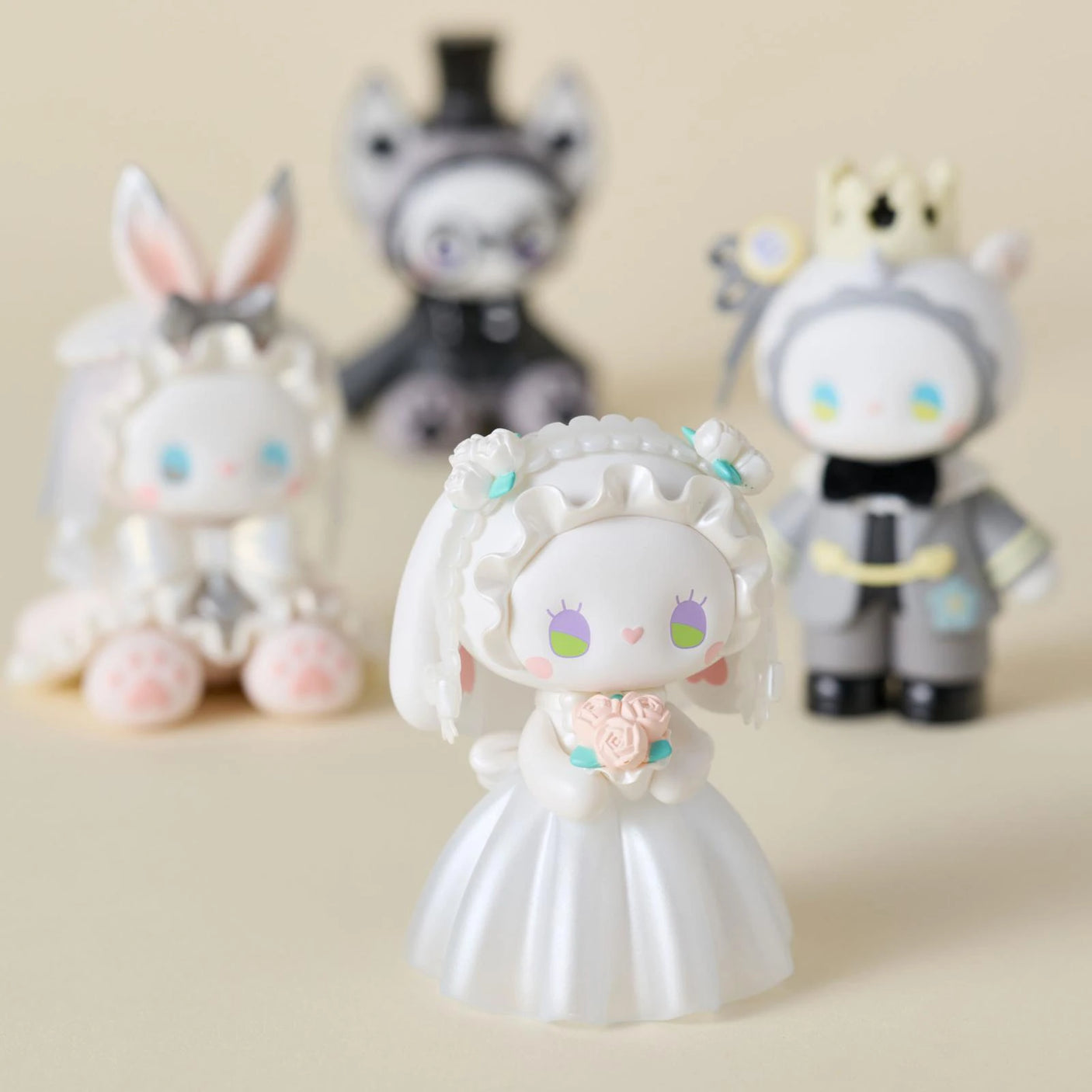 The Lucky Emma Secret Forest Wedding Blind Box features four pastel hand-painted figures: a bride in white with flowers at the front and three secret whimsical characters in the background for a charming display.