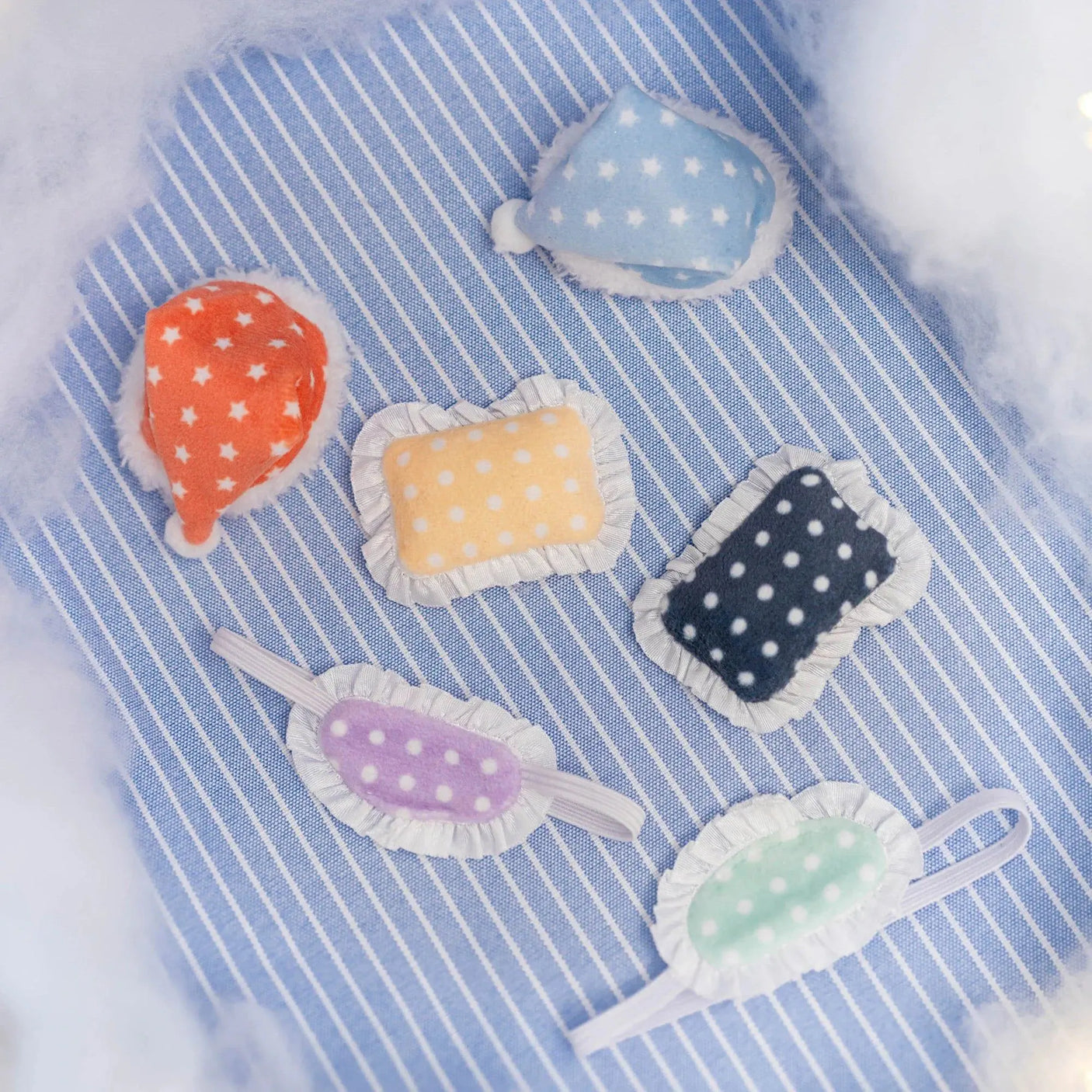 Soft fabric crib toy tags with star and dot patterns on a blue striped cloth