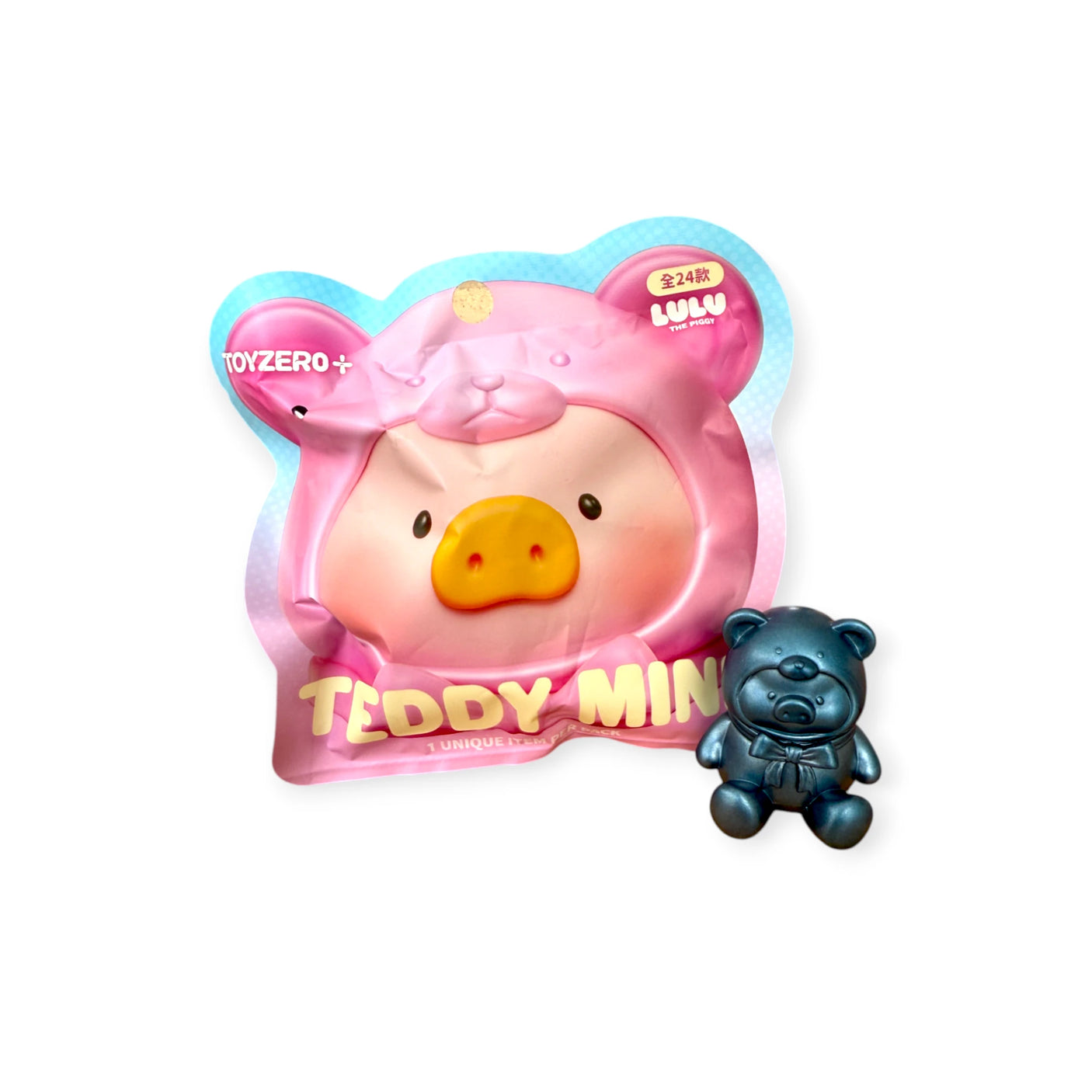 A LuLu The Piggy - Mini Teddy Blind Bag collectible by LuLu The Piggy sits next to a small metallic blue bear figurine—an ideal surprise toy, displayed on a white background.