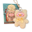 The LuLu The Piggy "Teddy LuLu the Piggy Plush Pal - Blind Box" keychain wears a yellow teddy bear onesie with a bow, displayed in front of matching LuLu The Piggy and TOYZERO+ packaging. A perfect collectible!