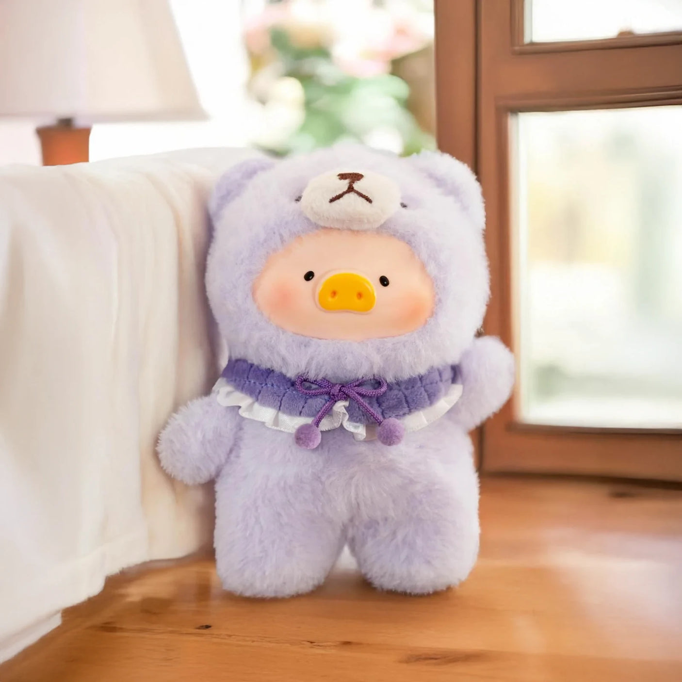The Joyful Time Lulu The Piggy Plush Pal - Blind Box by LuLu The Piggy features a pig-faced plush in a purple bear costume, standing on a wooden floor next to a white sofa and window—an adorable collectible.