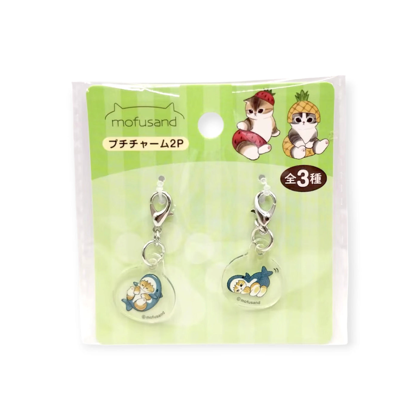 The Mofusand Mini Keychain Charm - 2 Piece Set features adorable fruit-themed cat charms, perfect for decorating bags or keys. Packaged with cute illustrations and Mofusand branding on a green background.