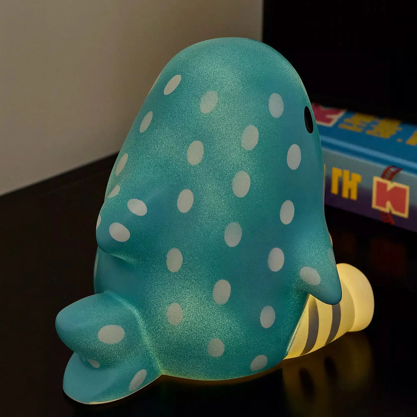 Teal shark-shaped touch light with white polka dots, lying pose and warm glow base.