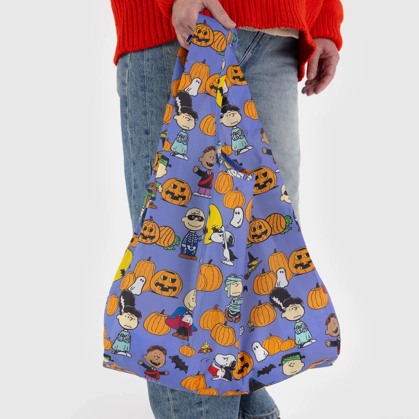 Blue tote bag with repeating PEANUTS characters and orange pumpkins, close-up pattern