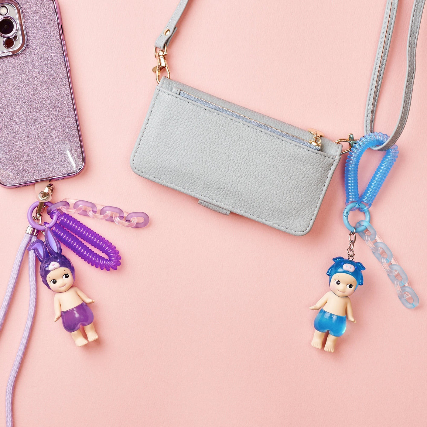 Doll keychain charms with gray crossbody bag and purple bunny charm