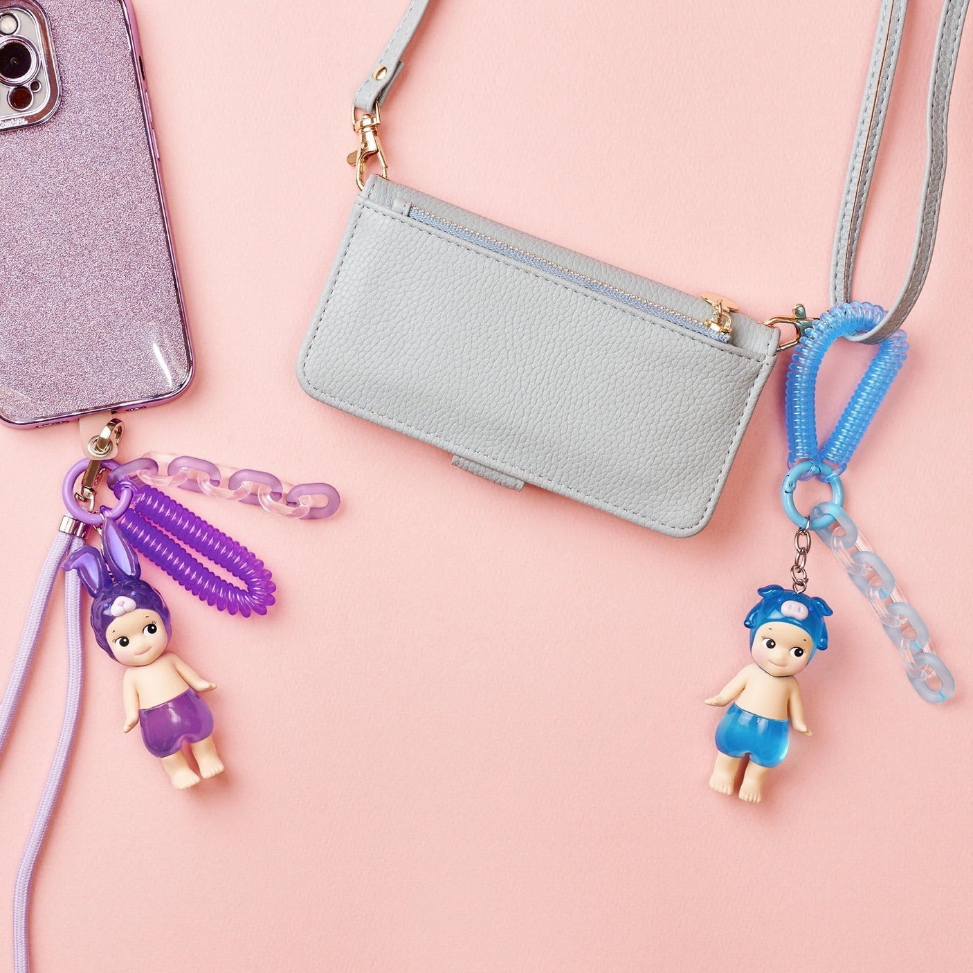 Doll keychain charms with gray crossbody bag and purple bunny charm