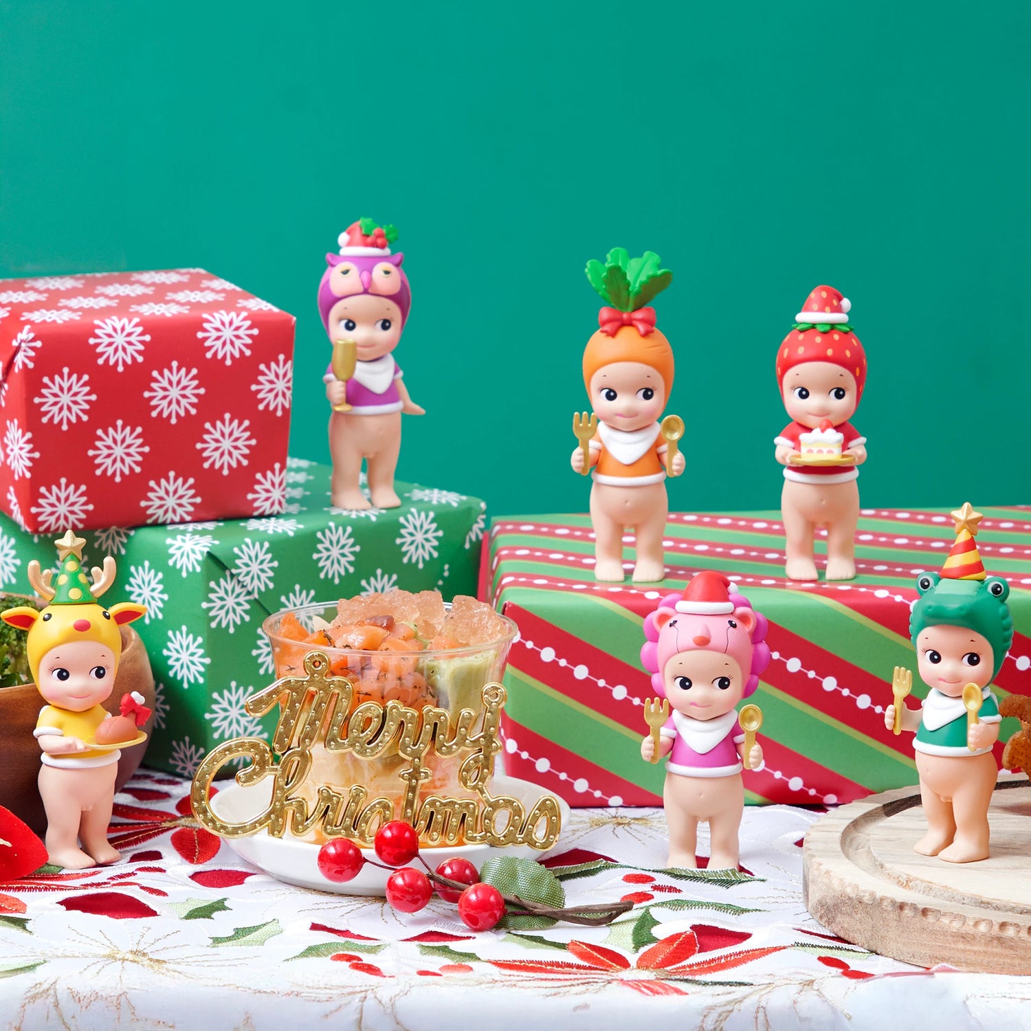 Five festive figurines, featuring a delightful Sonny Angel from the Christmas Dinner - Blind Box collection, are dressed in holiday-themed costumes and showcased on and around Christmas gift boxes and decorations against a green backdrop. Experience the joy of unboxing this enchanting collection by Sonny Angel, reminiscent of discovering treasures inside a blind box.