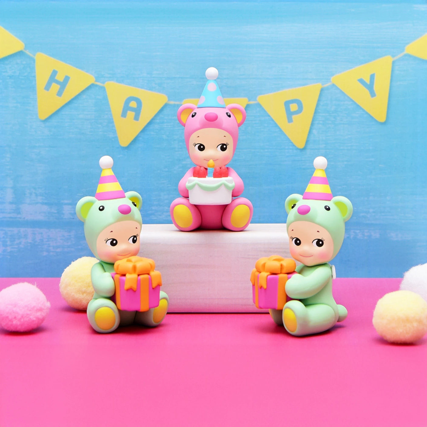 Birthday bear figurines with cake, candle, and Happy Birthday bunting