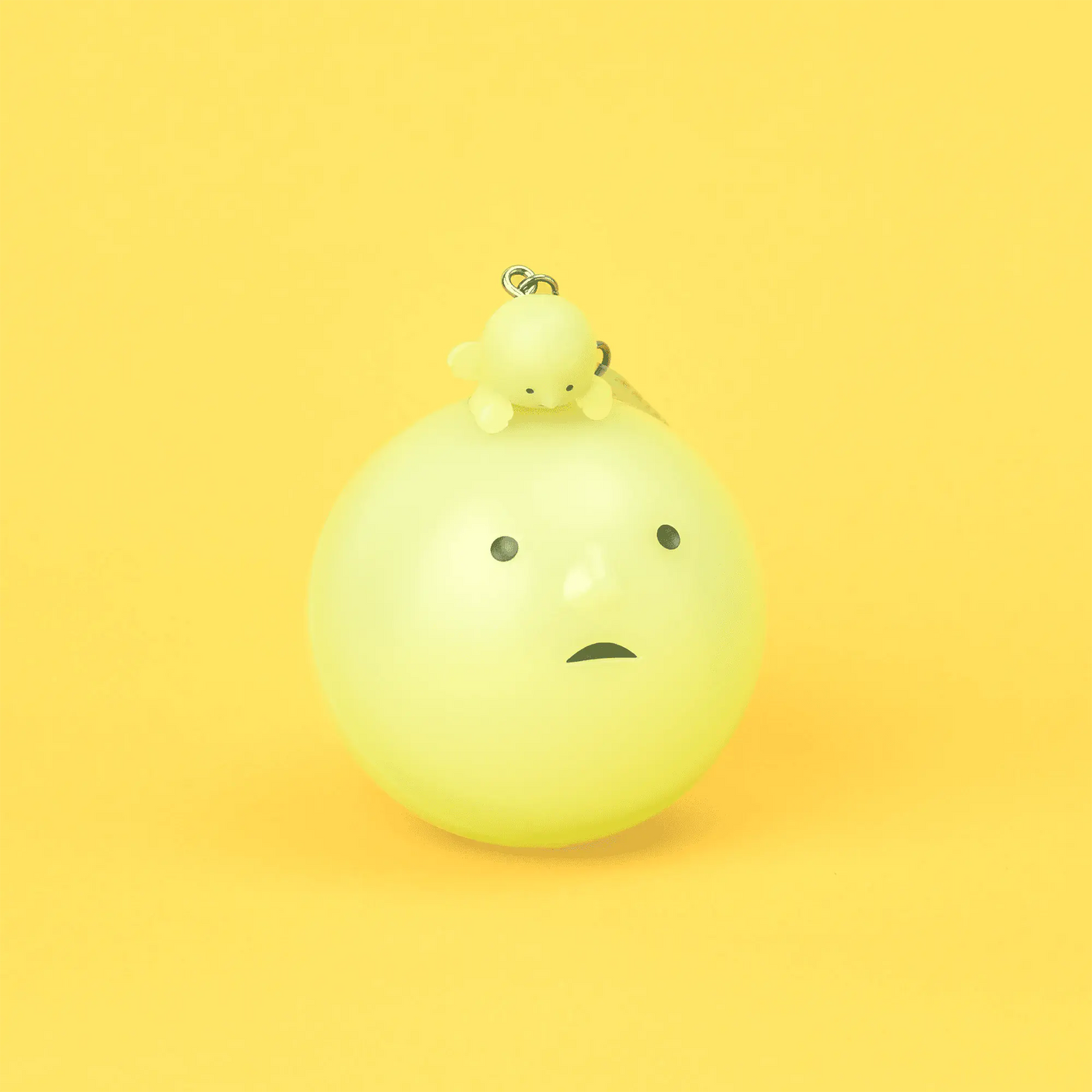 Lime green smiski bulb-shaped keychain figurine with small metal loop