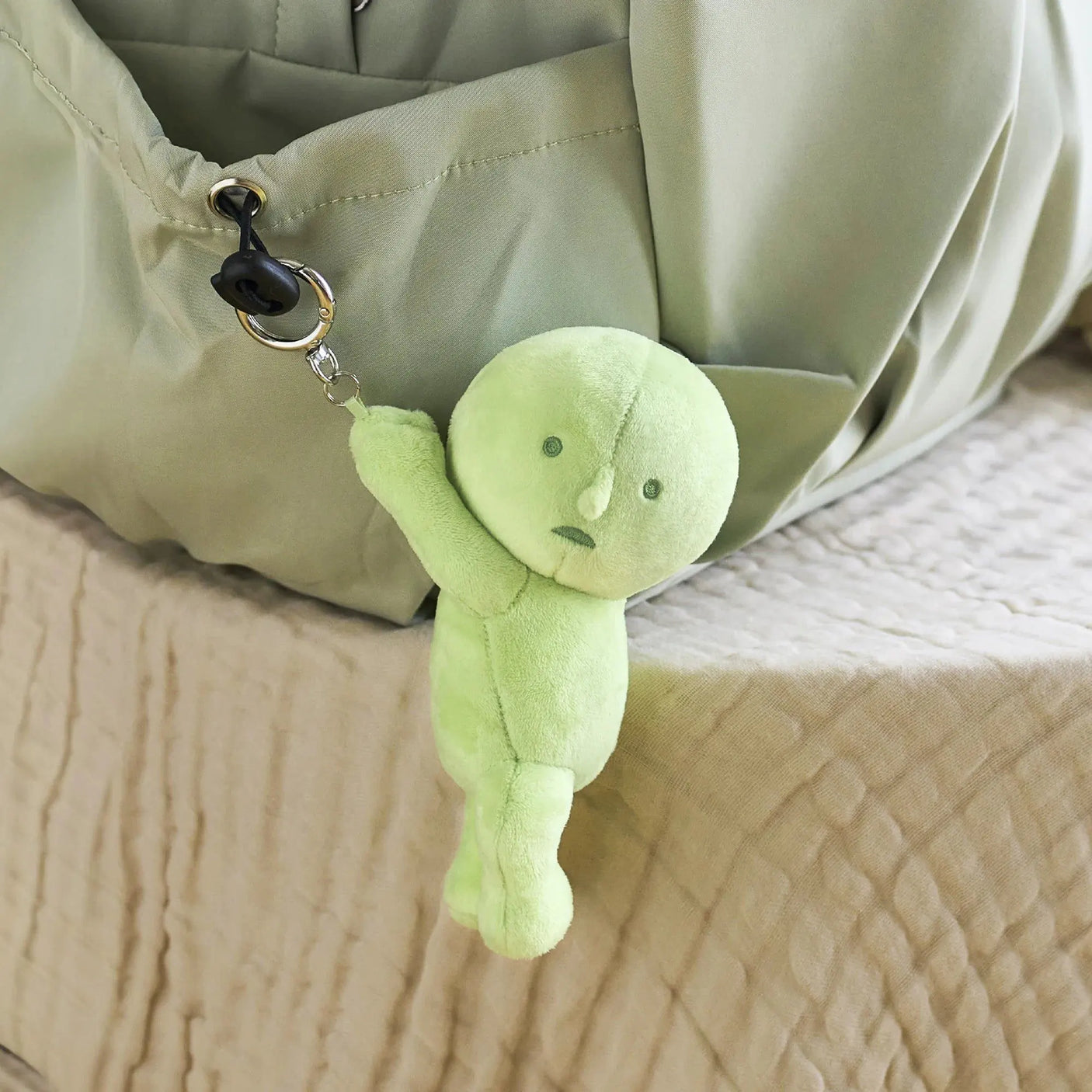 Light green plush keychain with metal ring and chain, round head and small face