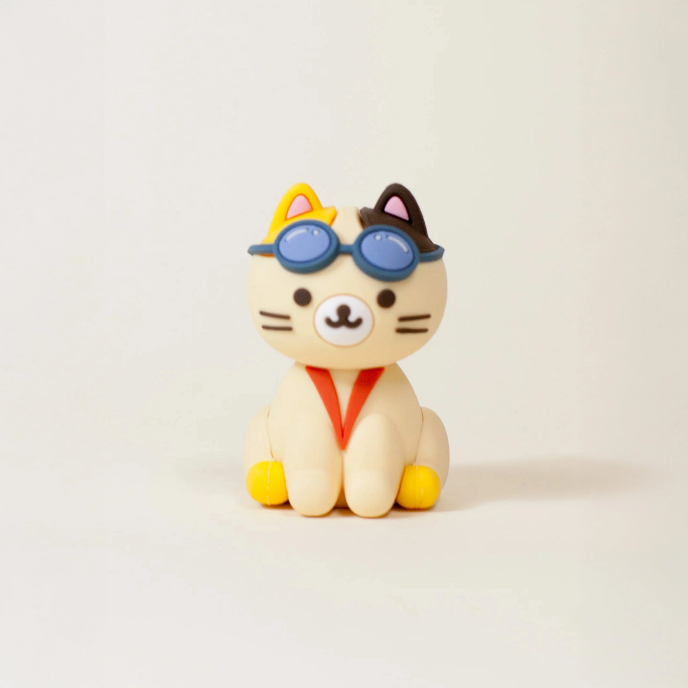 A cute Smoko Astrocats Blind Box cat figurine with blue goggles and a red scarf sits on a white background; this collectible by Smoko is perfect for fans.