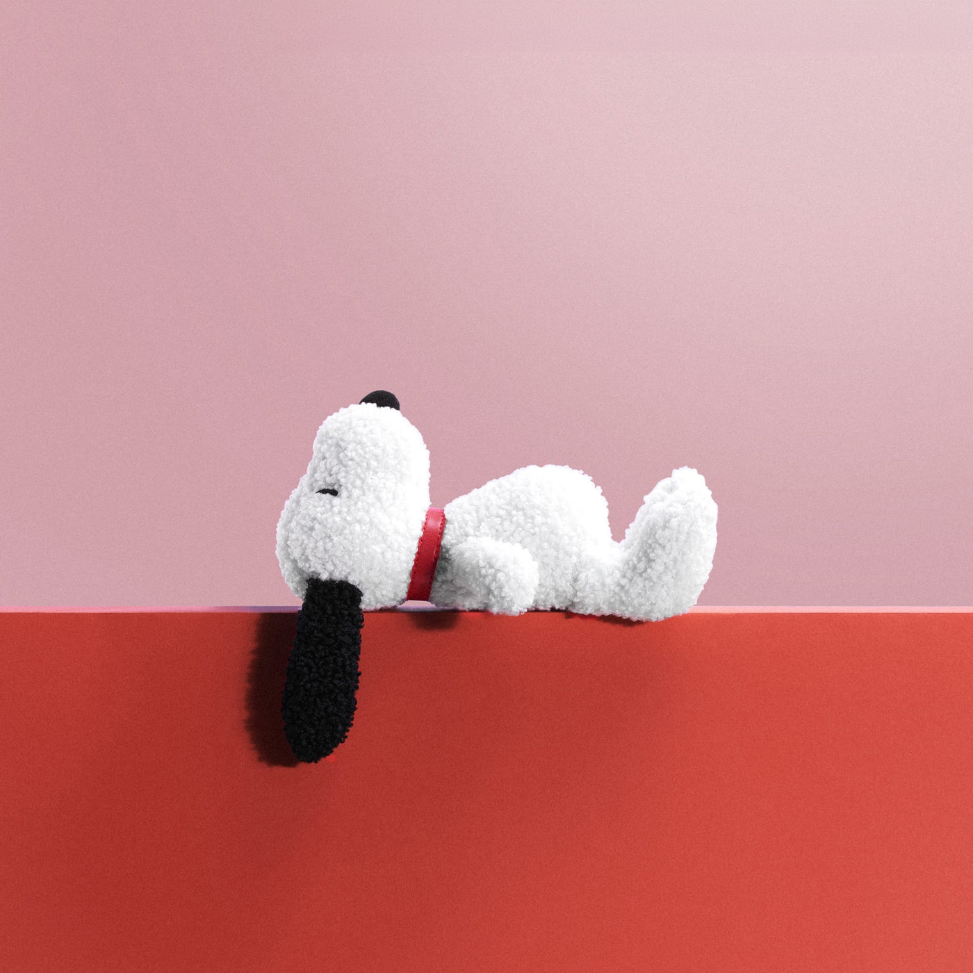 White and black plush Snoopy dog, lying down with floppy ears