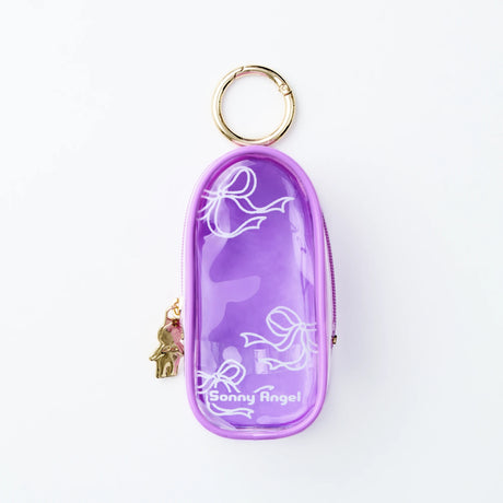The Sonny Angel My Bestie Case - Purple is a small, clear purple case with white ribbon designs, gold keyring, and Sonny Angel logo. A gold mini figure charm hangs by the zipper. Brand: Sonny Angel.
