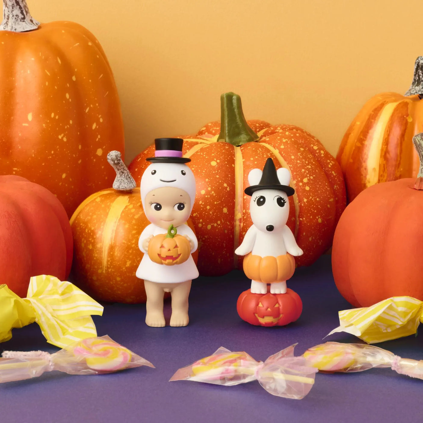Sonny Angel mini figures standing among pumpkins, in orange, white, and green
