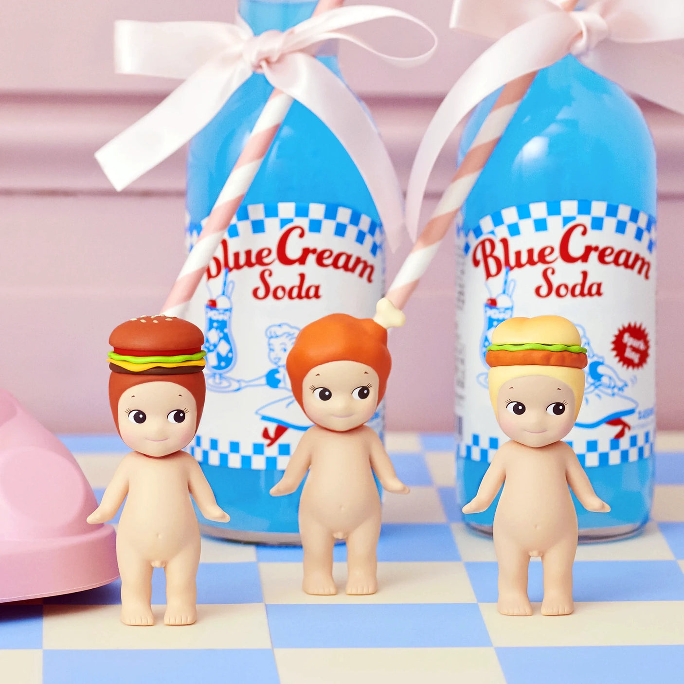 Three Sonny Angel Snack Series - Blind Box mini-figures from Sonny Angel, two with burger and sandwich hats and one bareheaded, stand before blue cream soda bottles—a charming surprise collectible set.