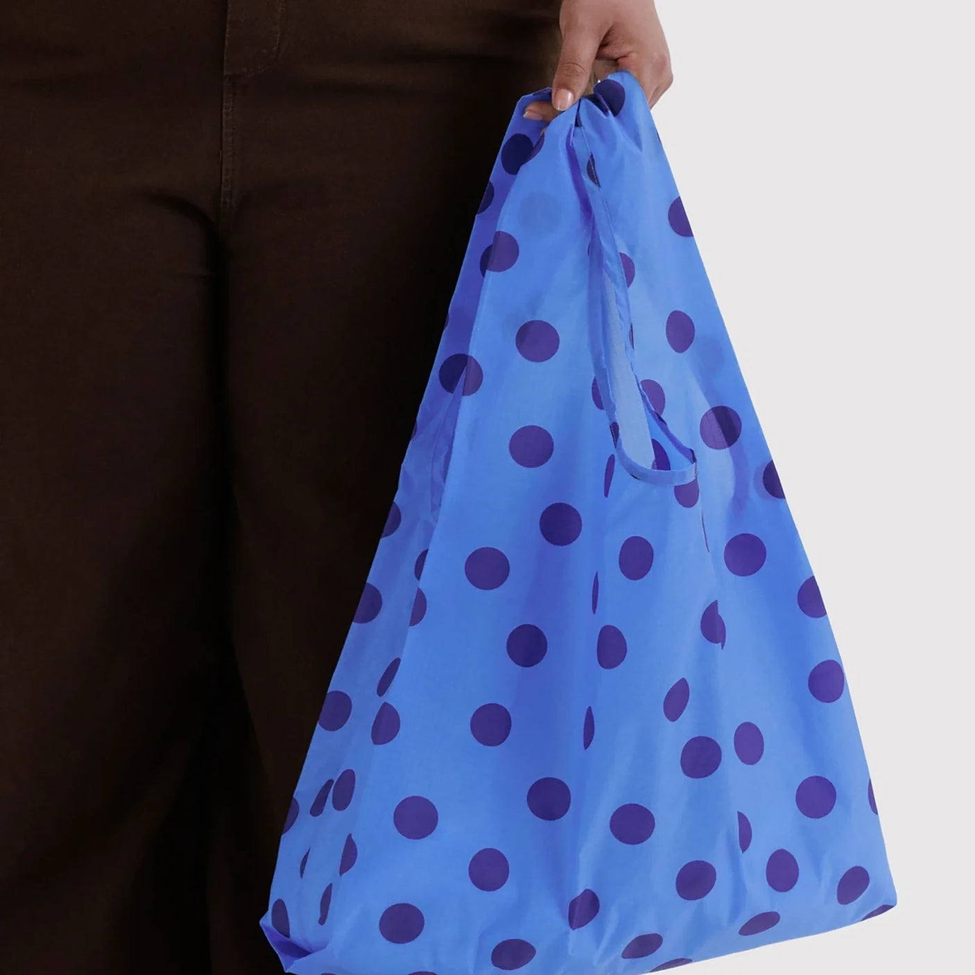 Blue polka dot reusable tote bag with gathered opening and carrying handles