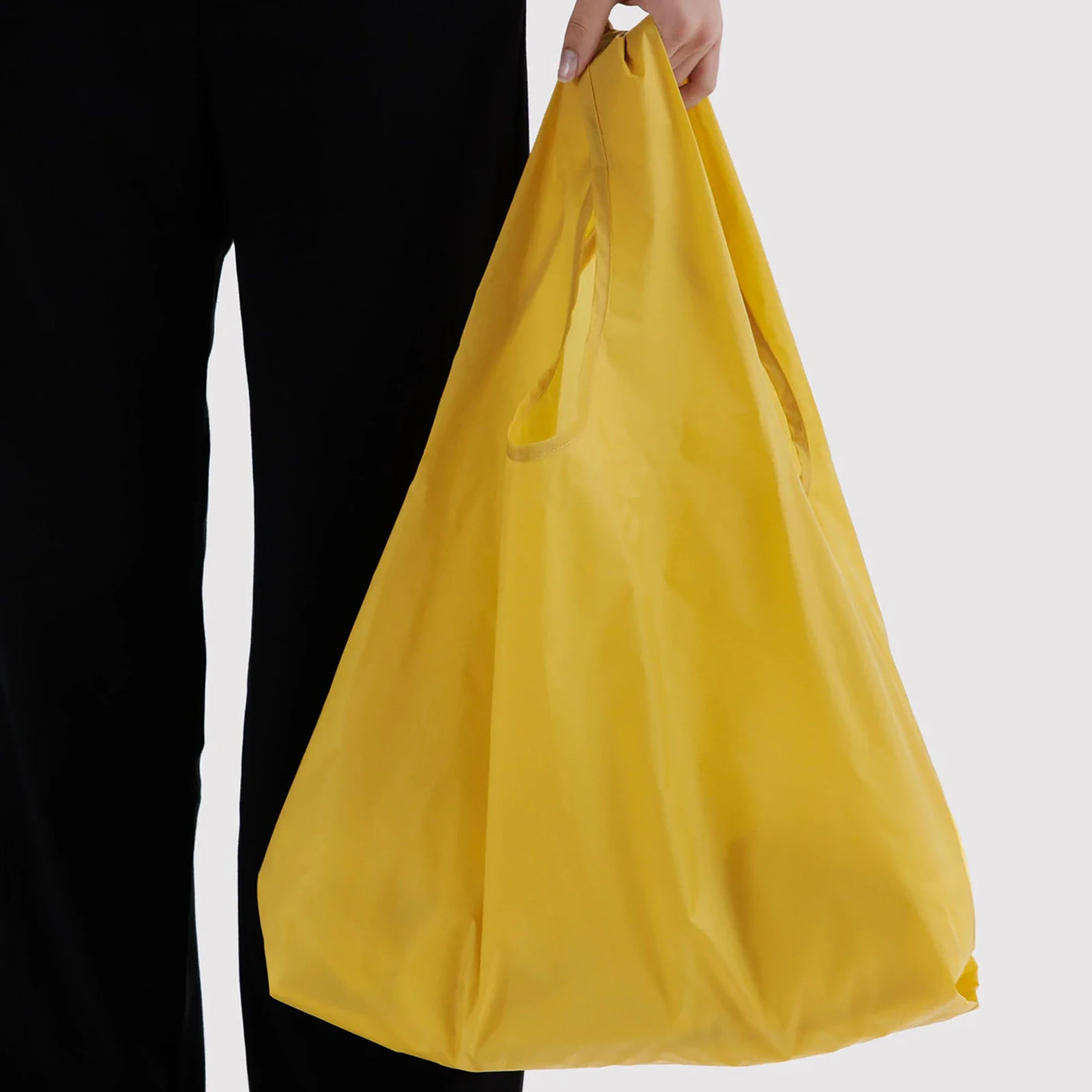 Sunflower yellow Baggu standard tote bag held for carrying