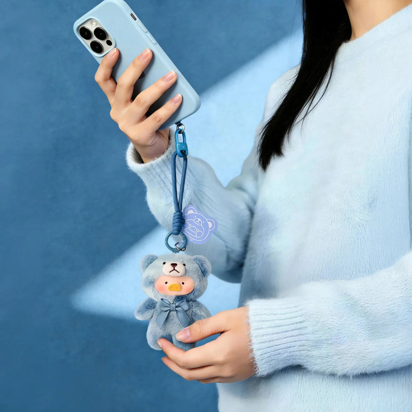 Teddy LuLu - Whispers of Nature Plush Charm - Blind Box showing a blue teddy-suit plush charm clipped to a phone by LuLu The Piggy