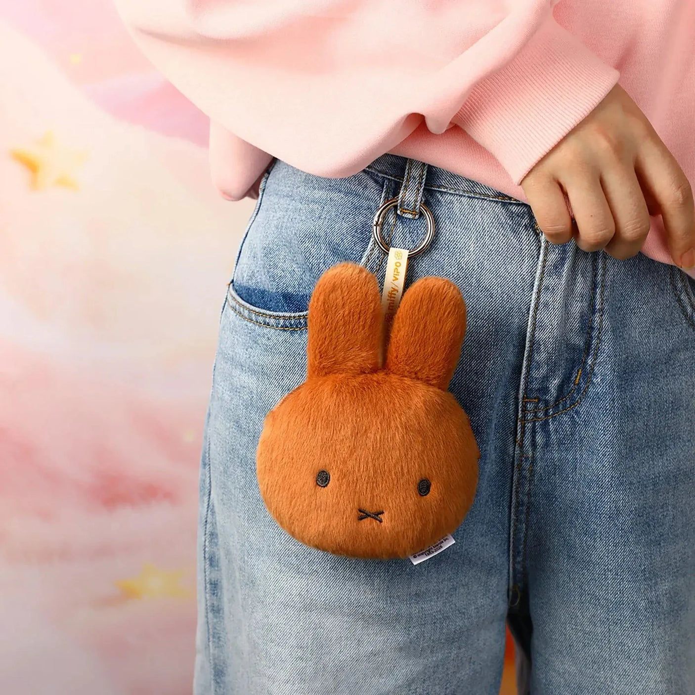 Plush rabbit pouch keychain clipped to denim jeans with metal key ring
