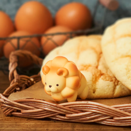 The Animal Bakery Blind Box - Vol 2 by Dreams Inc features a lion-shaped pastry on a wicker tray alongside two melon pan breads, with brown eggs in a wire basket adding charm to these whimsical treats.