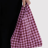Pink houndstooth Baggu baby tote held by hand, flexible fabric