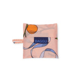 The Baby Baggu Reusable Bag - Apricots & Ribbons by Baggu is a compact, peach-colored reusable bag made from 100% recycled nylon, featuring an abstract design and a blue "BAGGU" label.