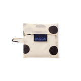 Cream baby tote bag with black polka dots, folded with wrist strap and BAGGU label