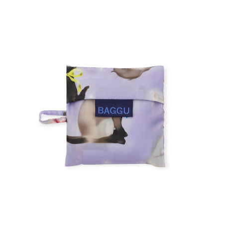 Compact folded Baby Baggu bag in soft lavender featuring illustrated cats with colorful ribbon bows and blue Baggu label