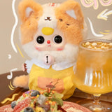 Baby Three - Kitten Wardrobe Keychain Blind Box doll in fluffy cream and orange cat costume with bell necklace and yellow outfit beside drink