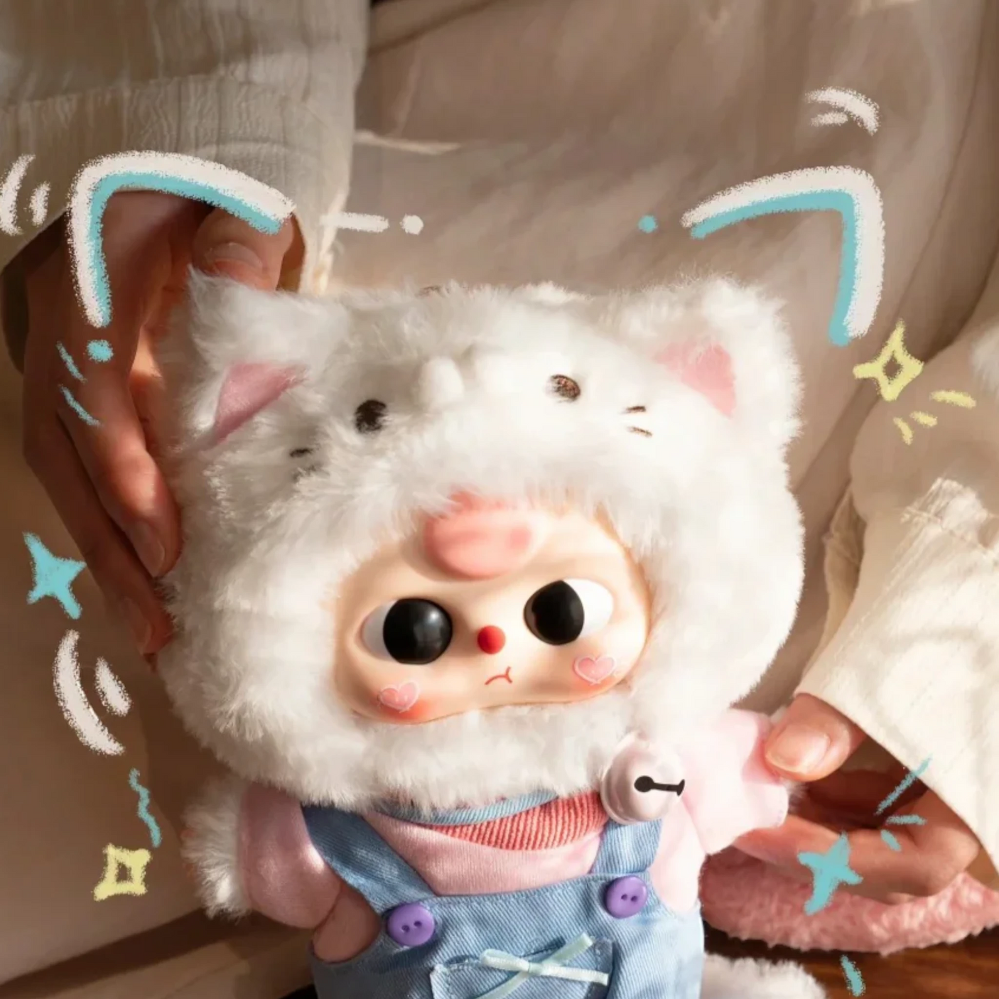 Baby Three - Kitten Wardrobe Keychain Blind Box doll in fluffy white cat costume with bell necklace and blue outfit held by hands
