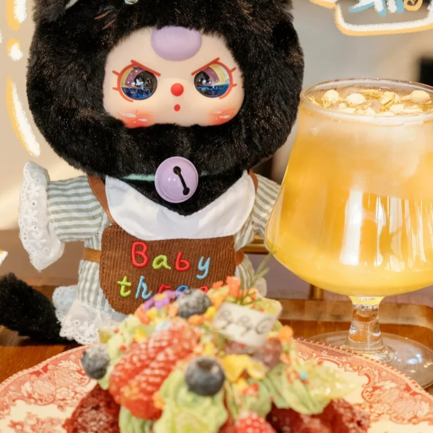 Baby Three - Kitten Wardrobe Keychain Blind Box doll in black cat costume with bell necklace, sitting beside dessert and drink